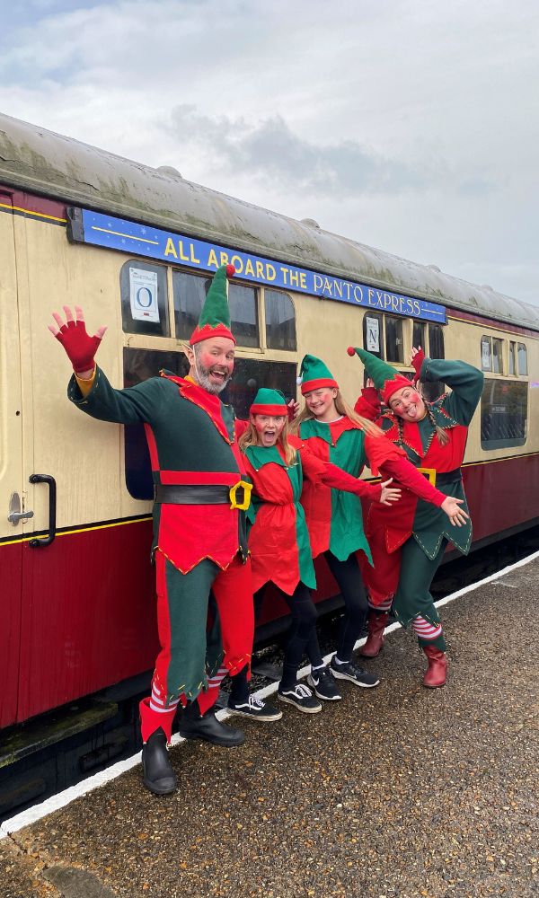 Elves in front of the Panto Express at Buckinghamshire Railway Centre one of the best Christmas train rides.