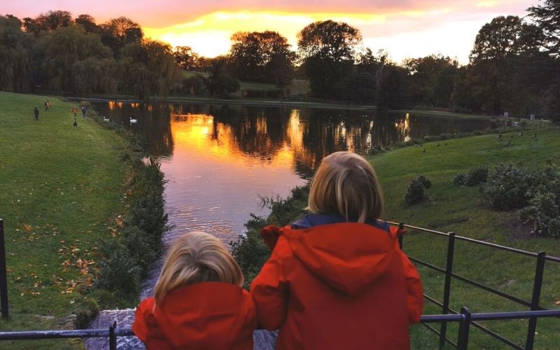 Two boys looking out over the lake at Leeds Castle at sunset