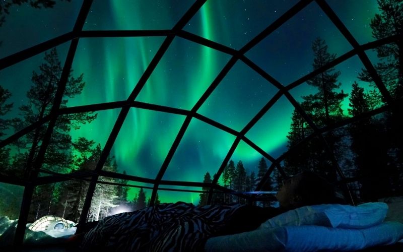 Watching the northern lights from an igloo in Lapland.