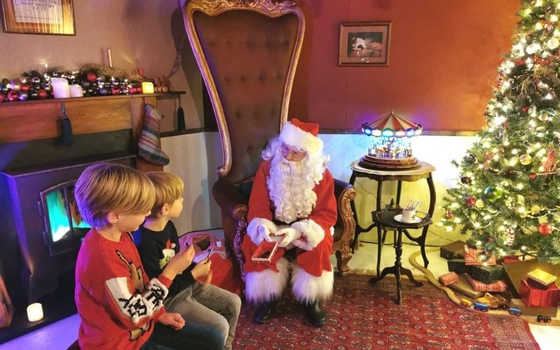 Two children visiting Santa at the Strand Palace - one of the best Santa's Grottos in London.