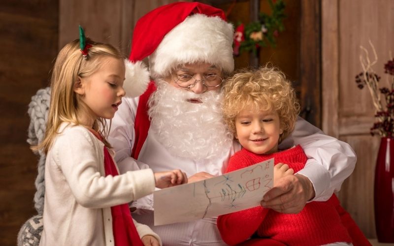 Santa reading to children at Santa sleepovers and Christmas at theme parks