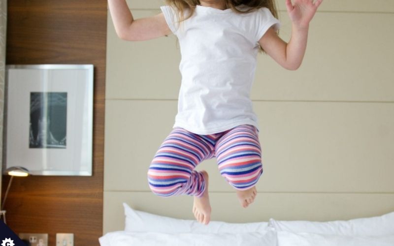 Girl jumping on a bed at the Park Plaza Hotel County Hall