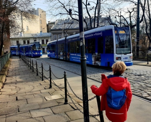 Boy in red jacket watching the trams in Krakow Poland.