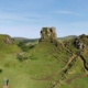 Kids standing in the stone circle of the Fairy Glen on the Isle of Skye with clear blue skies.
