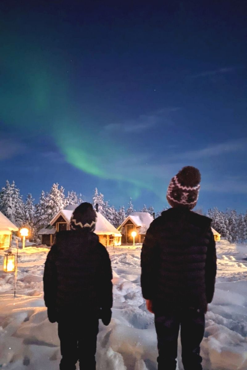 Two little boys watching the Northern Lights at the Levi Northern Lights Village.