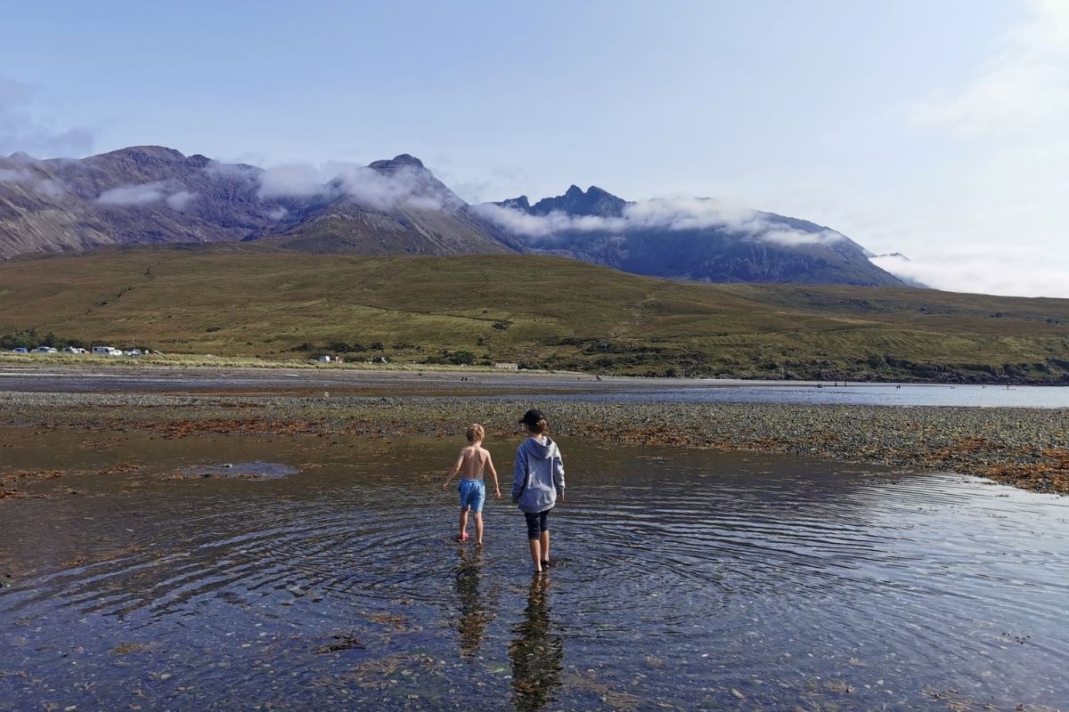 Two young boys wading in the water at Glenbrittle beach on the Isle of Skye.