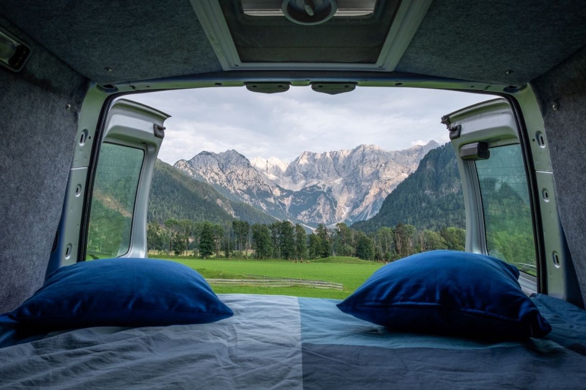 View out of the back of a campervan towards mountains.