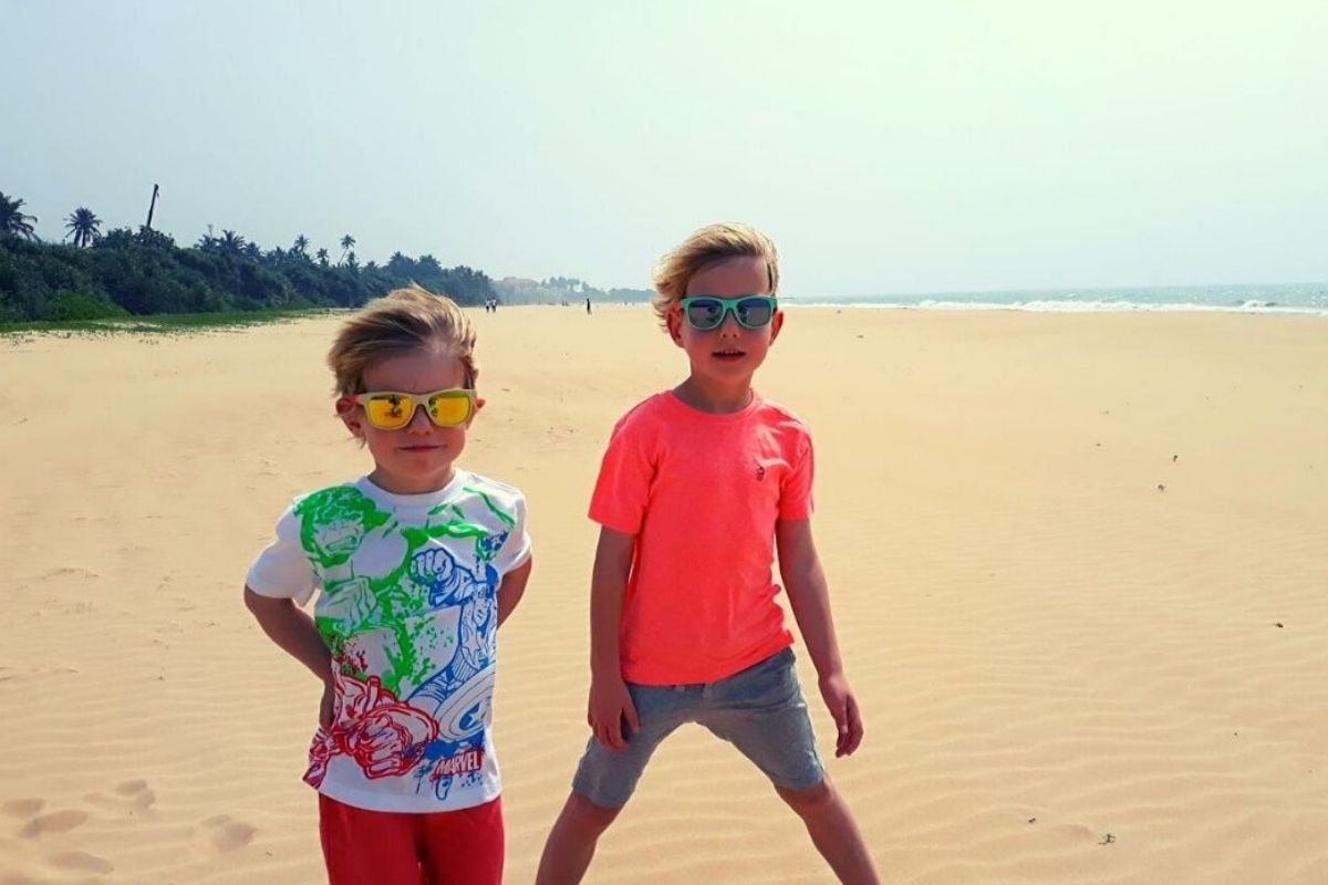Kids on an enormous stretch of sand at Bentota Beach in Sri Lanka.