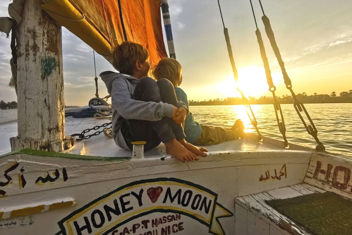 Two boys enjoying a sunset felucca trip down the Nile in Luxor.