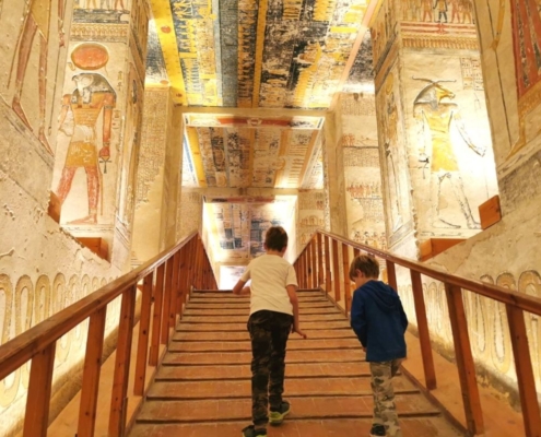Two boys exiting the sarcophagus of Rameses V in the Valley of the Kings.