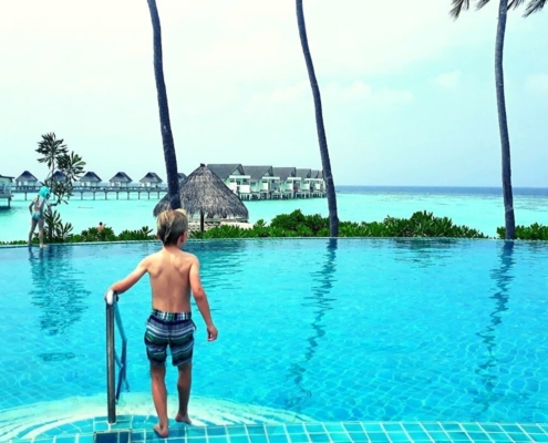 Boy stepping into the pool at the Centara Grand Island Resort & Spa Maldives.