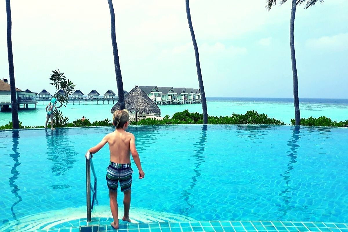 Boy stepping into the pool at the Centara Grand Island Resort & Spa Maldives.