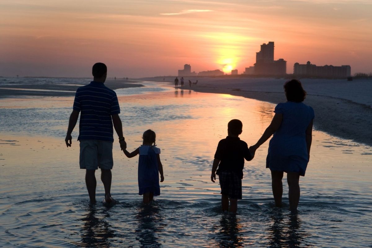 Family walking along a Florida beach at sunset.