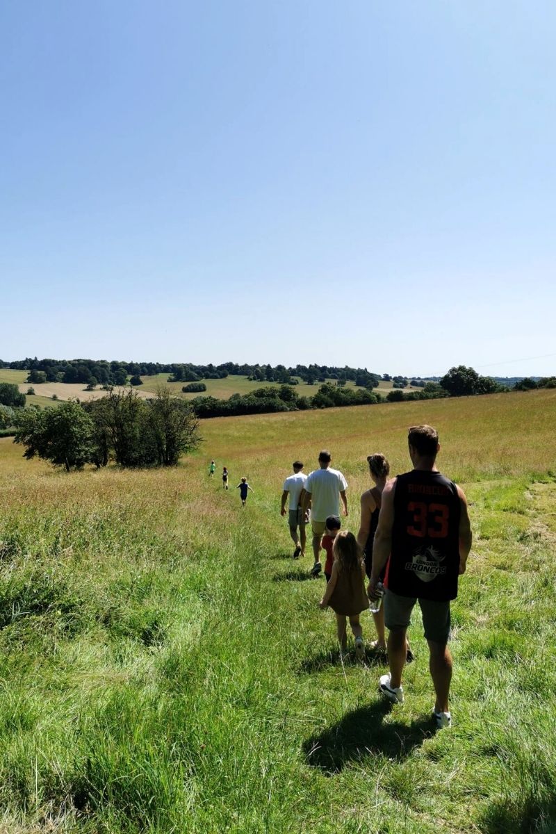 Group of friends going on a walk in the countryside while camping with kids.