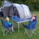 Two boys sitting in chairs on a campsite.