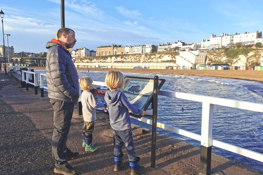 Family reading an information board in Broadstairs in Kent.