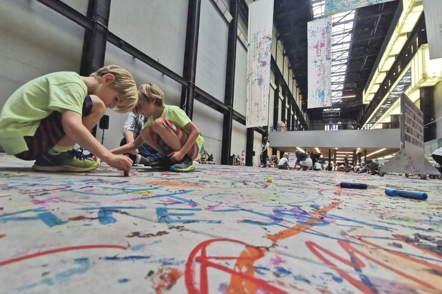 Kids colouring the floor of the Turbine Hall in the Tate Modern in London.