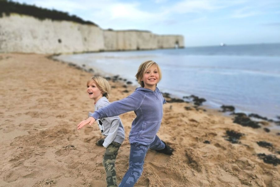 Two boys playing on Kingsgate Bay beach in Kent on the Viking Coastal Trail - one of the top things to do in Broadstairs.