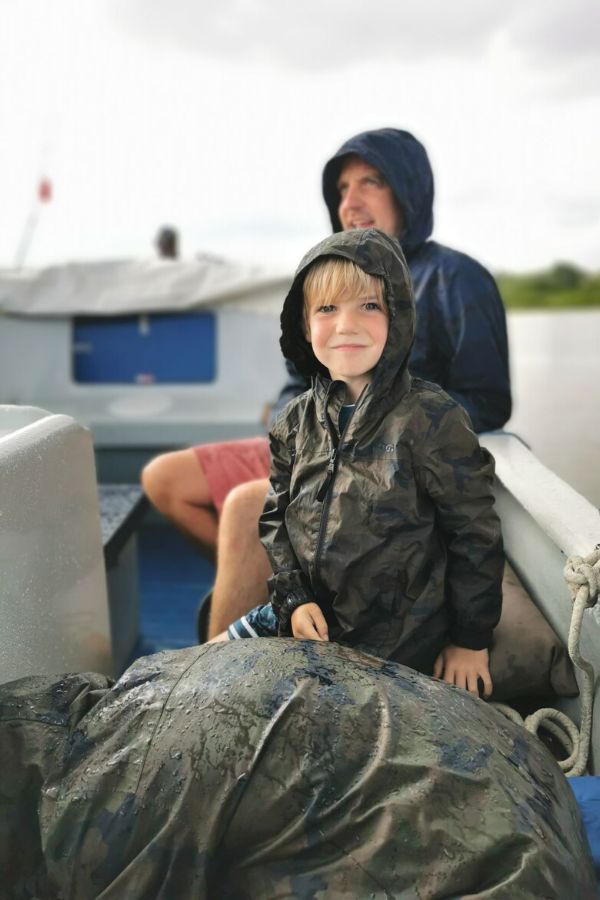 Family on a boat in the rain wearing TOG24 lightweight packable jackets.