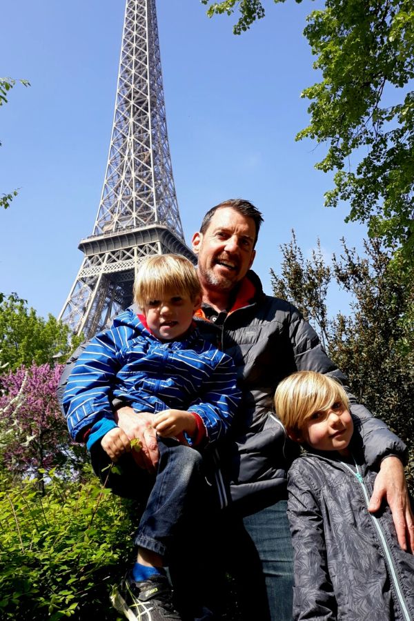 Family standing in front of the Eiffel Tower in Paris.