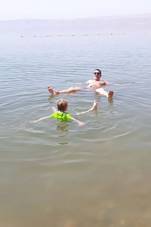 Father and son floating in the Dead Sea in Jordan.