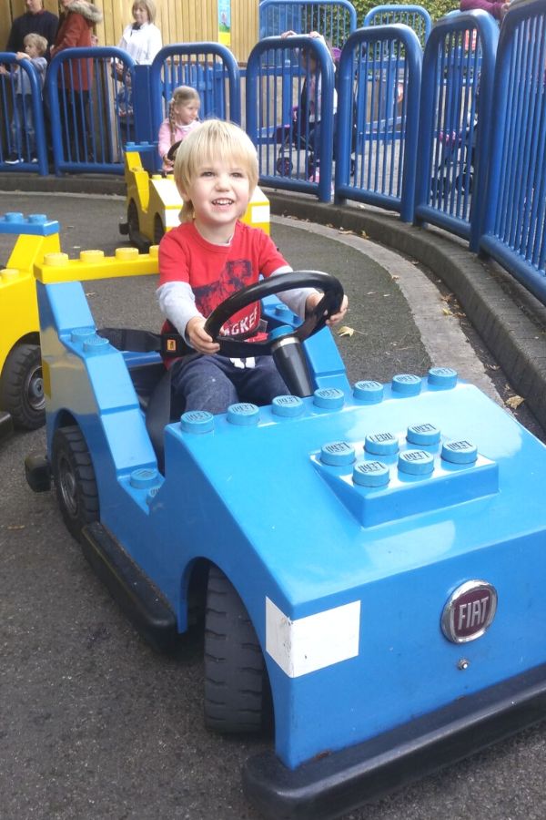 Little boy driving a Lego car at Legoland Windsor - one of the best family days out from London.