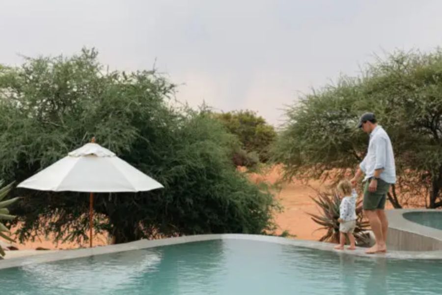 Father and son walking around the pool at Tswalu Kalahari Game Reserve in South Africa.