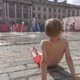 Little boy cooling off by one of the splash parks in London at Somerset House.
