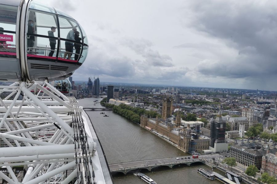 People standing in one of the London Eye pods looking at the London skyline.