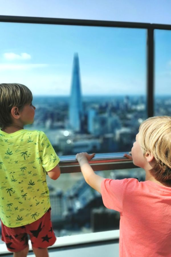 Two little boys looking at the view of the Shard from the Sky Garden in London.