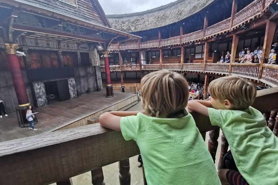 Two little boys watching a rehearsal at The Globe Theatre, one of the top London attractions for kids.