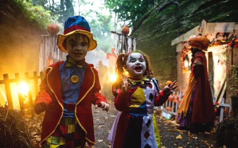 Little boy and girl dressed in Halloween costumes for Halloween fun at Warwick Castle - one of the best UK Halloween breaks for families.