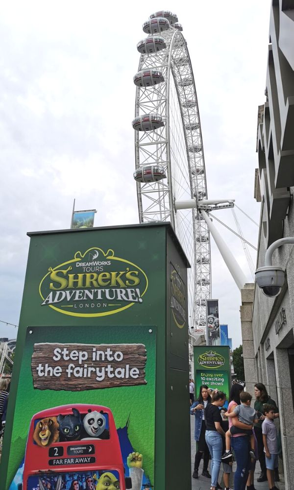 Advert for Shrek's Adventure with London Eye in the background.