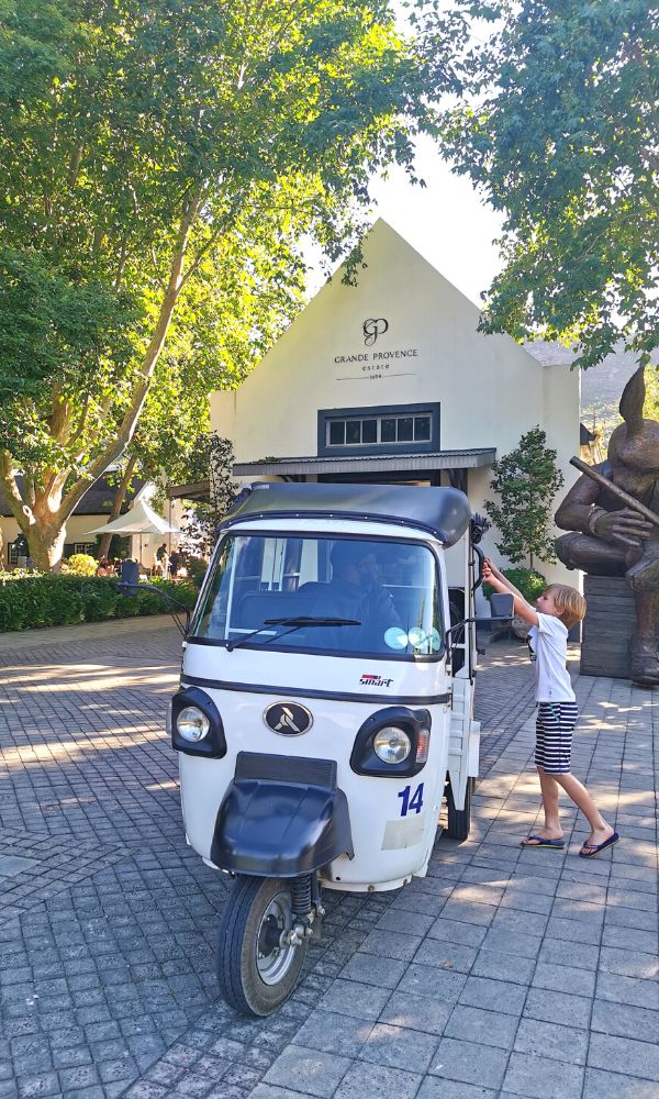 Child stepping into a tuk tuk at Grand Provence wine estate in Fraschhoek.