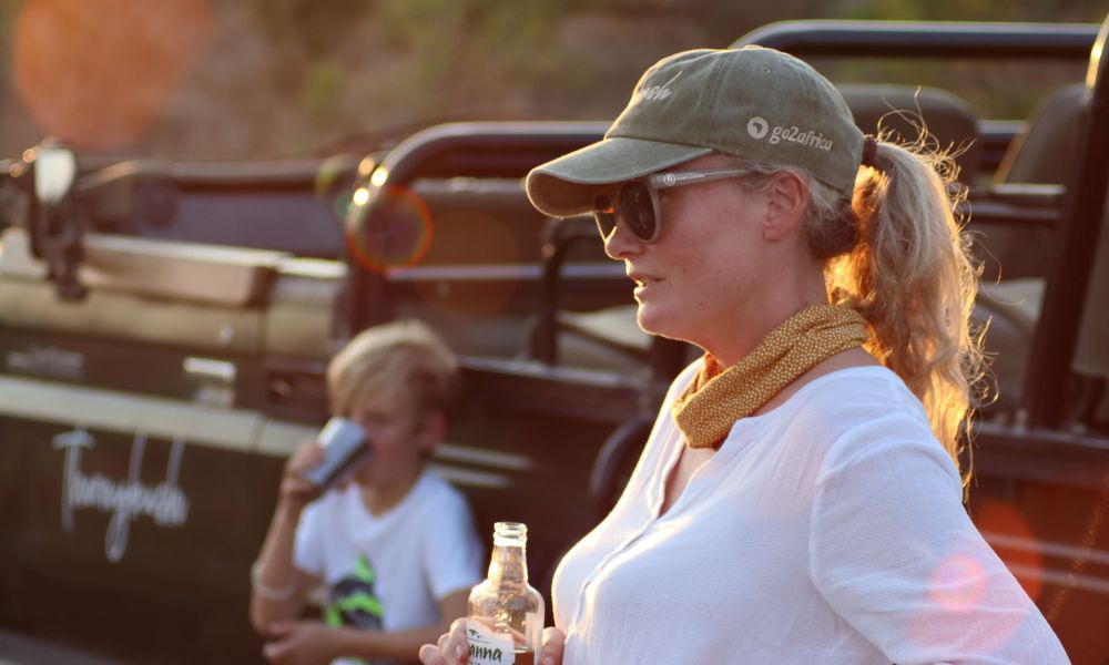 Family on safari at Jackalberry Lodge enjoying sundowners on a game drive.