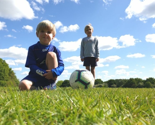 Photo of two young footballers taken from grass level.