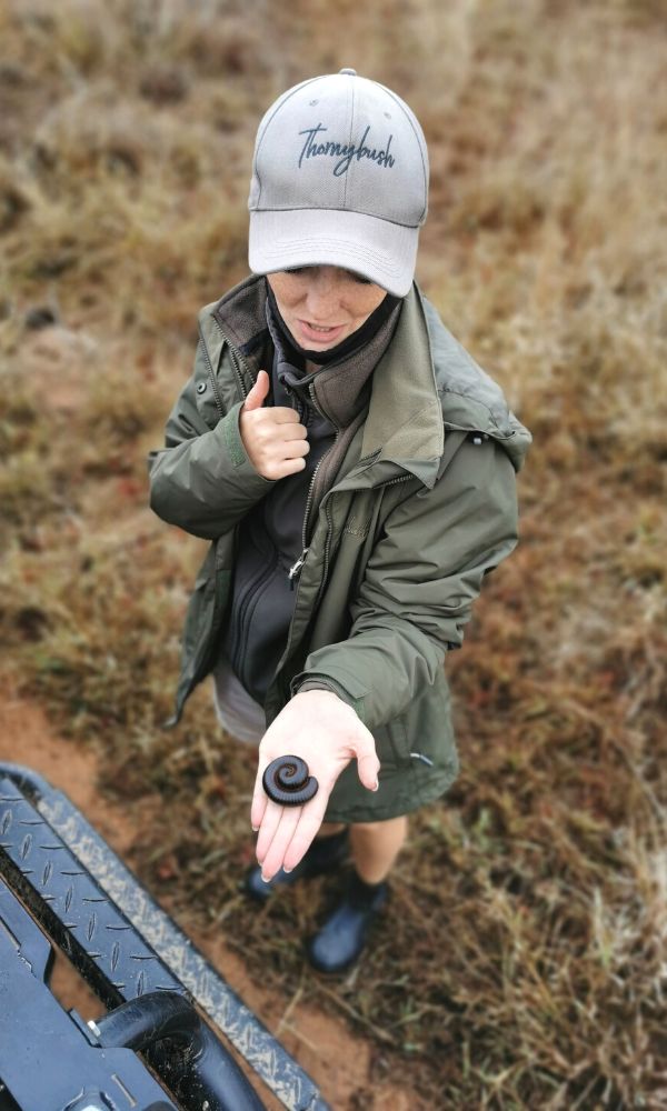 Safari guide at Thonrybush Game Lodge with a milipede in her hand.