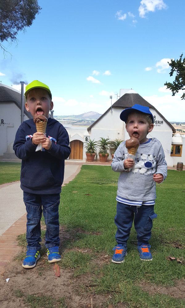 Two little boys eating enormous chocolate ice creams at Spice Route in South Paarl.