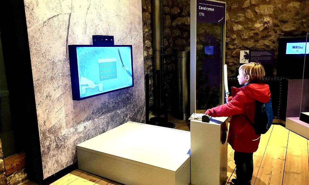 Child playing an interactive game in the White Tower at the Tower of London.