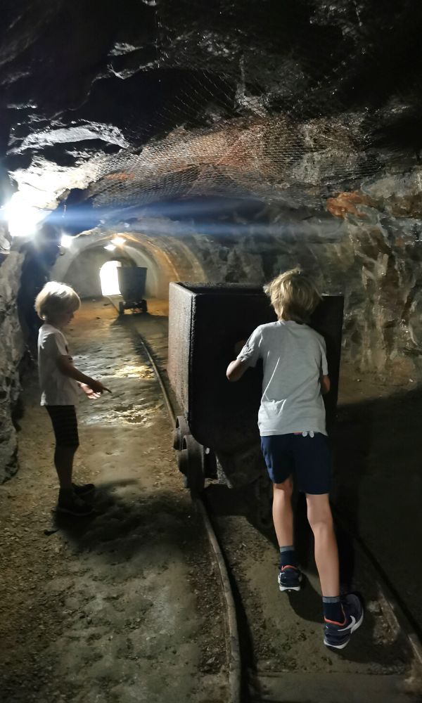 Children pushing an old mining cart through a disused mining tunnel at the Kammerhof in Banska Stiavnica in Slovakia.