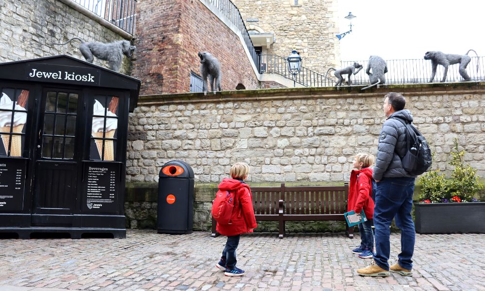 Family visiting the Tower of London looking at the monkey statues.