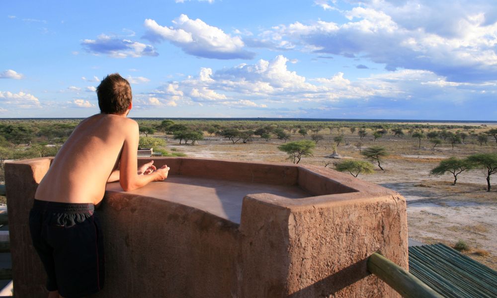 Man taking in the incredible views of Onguma Game reserve next to Etosha National Park in Namibia from Onguma Fort.