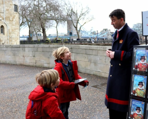 Kids buying a guide book at the Tower of London.