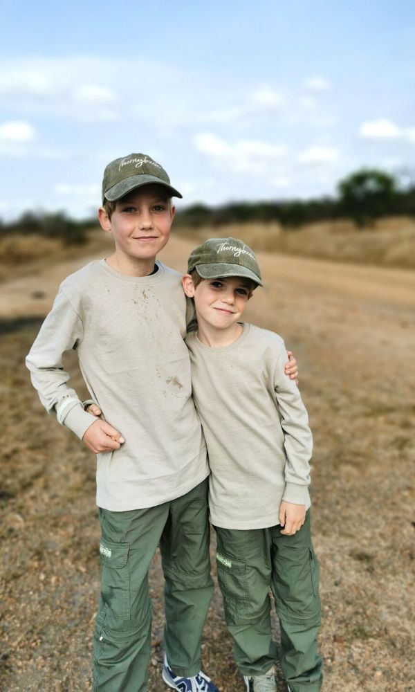 Kids wearing safari clothes on safari in South Africa.