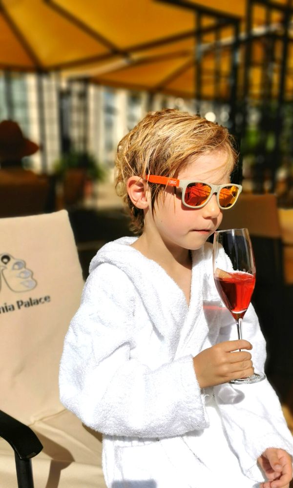 Young boy in a spa robe drinking a welcome drink at the Thermia Palace hotel in Slovakia.