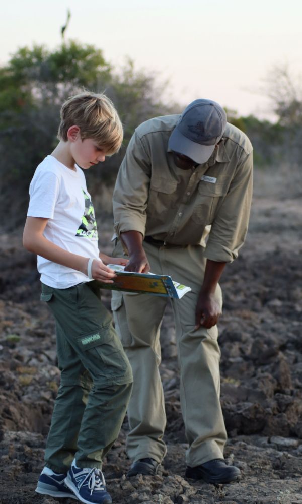Young boy with a game spotter on safari.