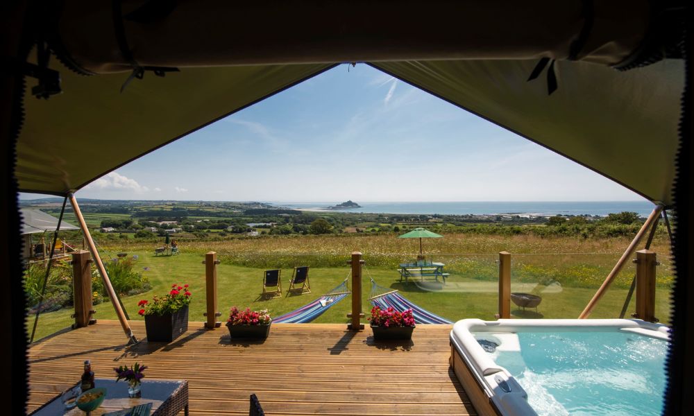 View out of a safari tent with hot tub across to St Michael's Mount in Cornwall.