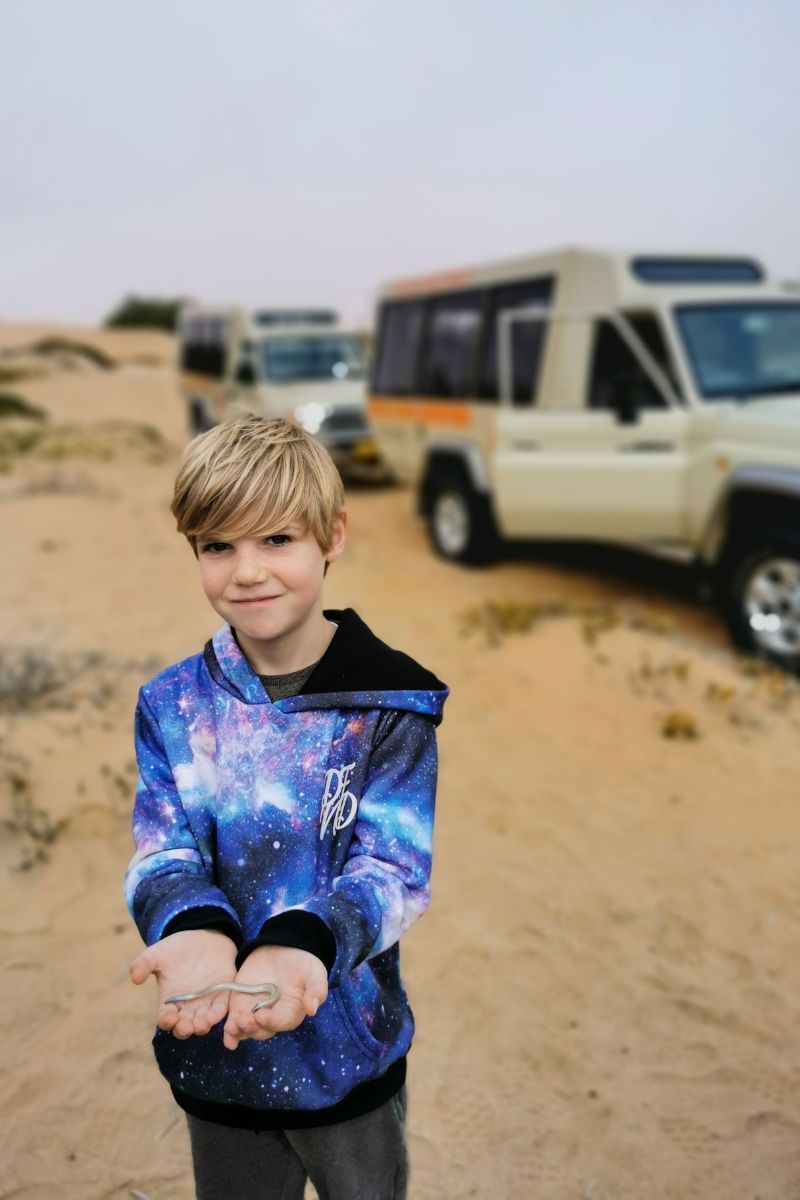 Boy holding a slow worm on a living desert tour in the Dorob National Park in Swakopmund in Namibia.