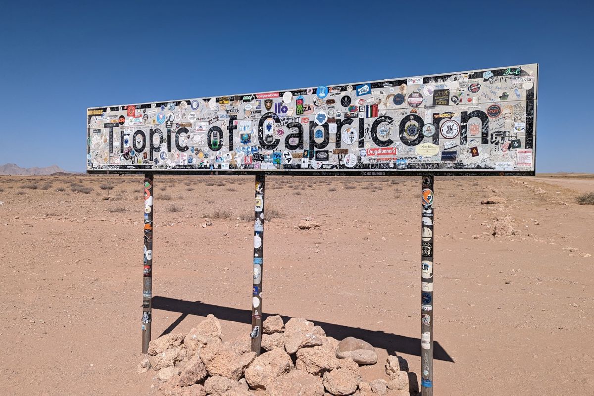 Tropic of Cancer sign with lots of stickers all over it on the C14 from Walvis Bay to Sesriem.