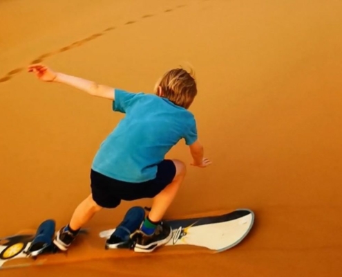 Child sand boarding in Zagora i n Morocco.